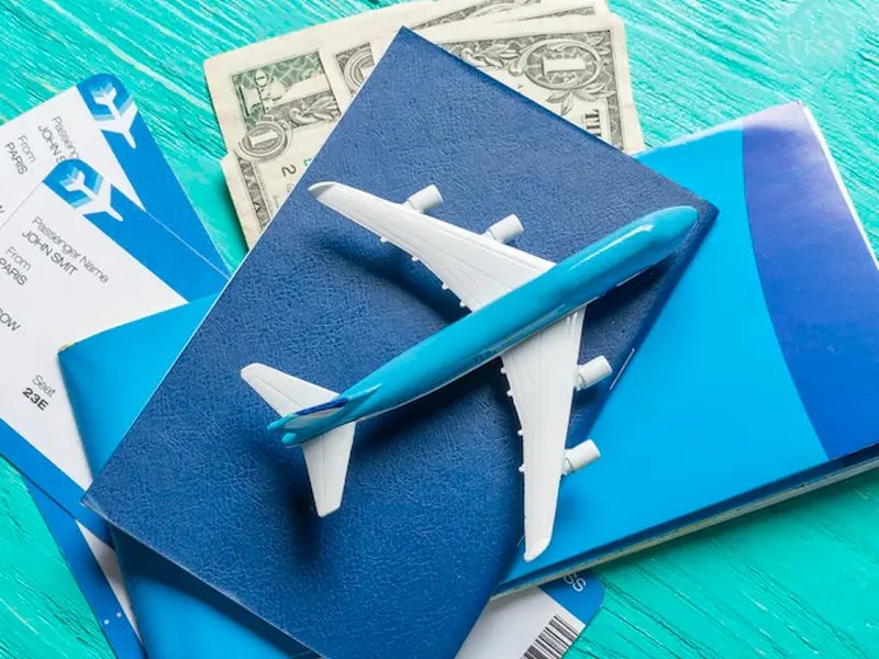 Model aeroplane resting on a passport and boarding passes